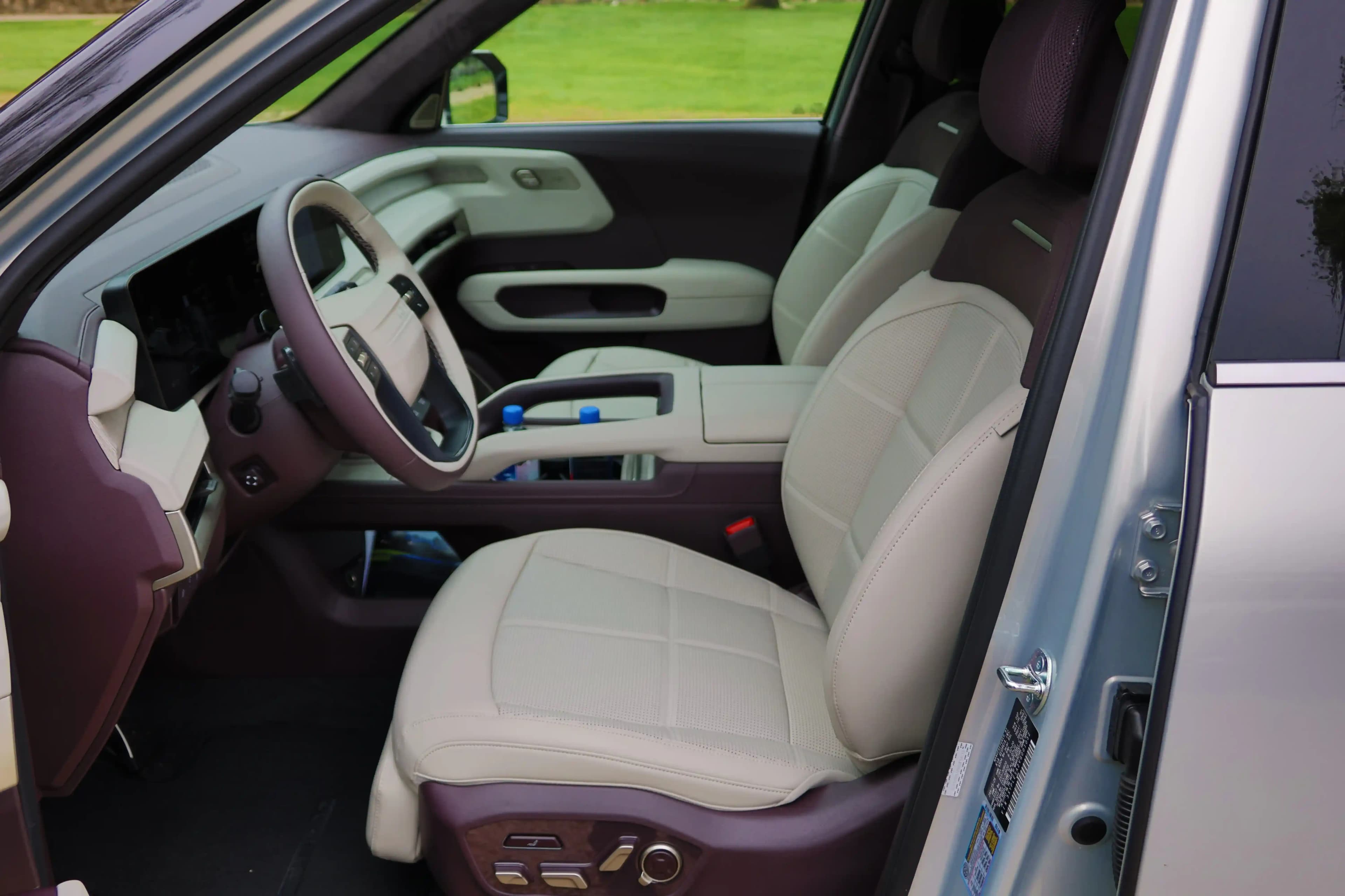 Front interior of a two-tone SUV with cream seats and a digital dashboard.